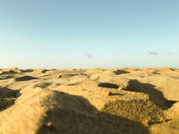 Surface level of sand dunes against sky