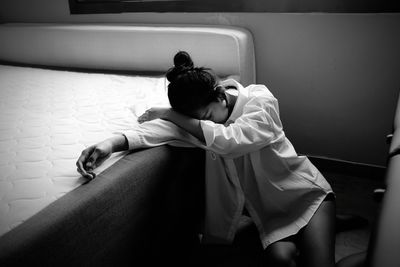 Low angle view of young woman looking through window