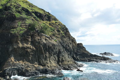 Rock formations by sea against sky