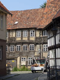 Houses by buildings in town against sky