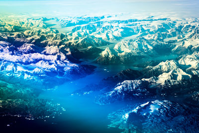 Aerial view of sea and snowcapped mountains