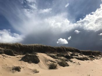 Scenic view of sand dunes against sky