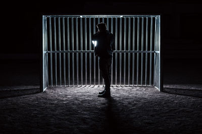 Silhouette of man standing by window