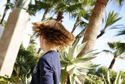 Rear view of man standing on palm tree