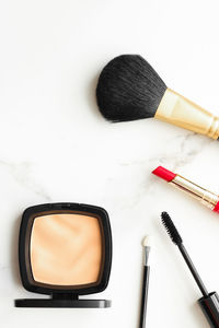 High angle view of make-up brushes against white background