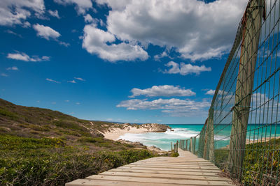 Wooden walkway leading to indian ocean beach, de hoop nature reserve, south africa against sky