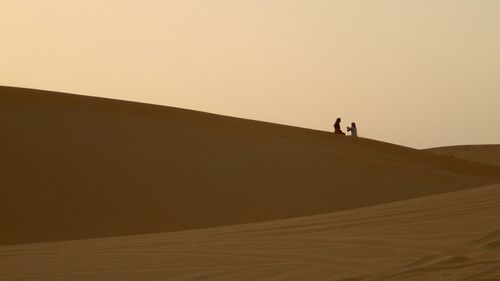 Silhouette of people against clear sky