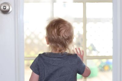 Rear view of girl standing at home