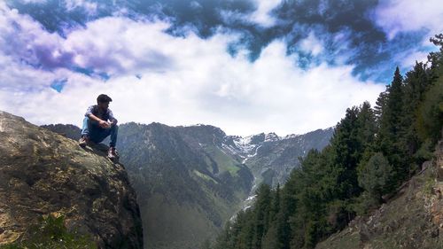 Rear view of man on mountain against sky