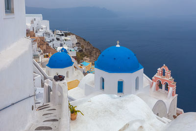 Detail of blue dome and bougainvillea in the village of oia, santorini, greece