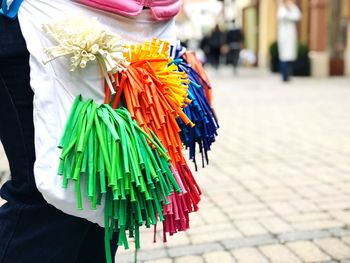 Close-up of woman holding multi colored umbrellas at market