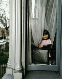 Portrait of girl sitting in window
