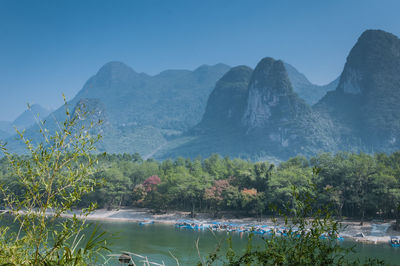 Scenic view of lake and mountains against clear sky