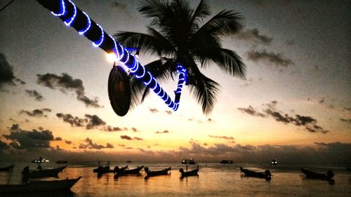 Boats in sea at sunset