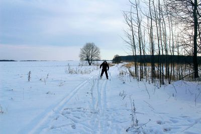 Man standing on snow field against sky
