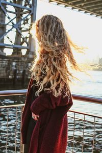 Rear view of woman standing by railing