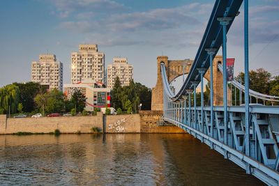 Bridge over river against cloudy sky