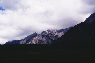 Scenic view of mountains against cloudy sky