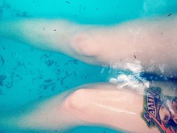 Midsection of woman swimming in pool