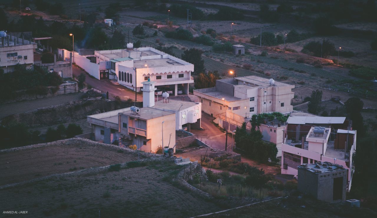 HIGH ANGLE VIEW OF ILLUMINATED BUILDINGS IN CITY AT DUSK