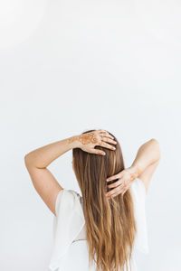 Rear view of woman standing against white background