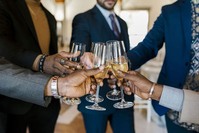 Hands of elegant men toasting champagne at banquet