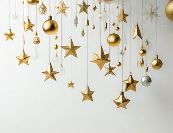 Close-up of christmas decorations hanging against white background