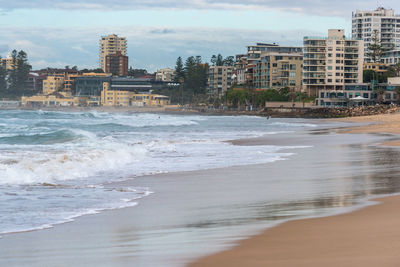 Scenic view of beach against sky in city