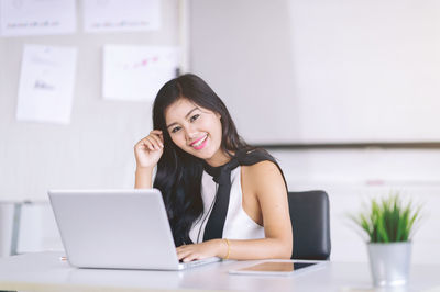 Young woman using phone on table