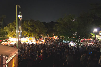 Crowd on road against sky at night