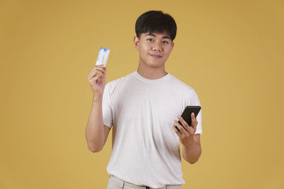 Portrait of smiling young man using mobile phone