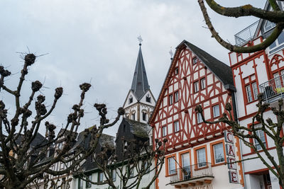 Low angle view of trees and buildings against sky