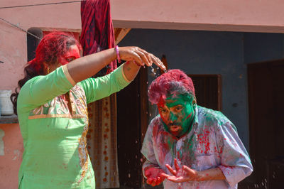 Happy friends playing holi in yard