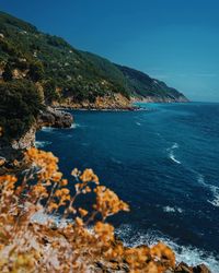 Scenic view of sea and mountains against blue sky