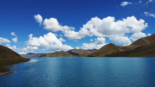 Panoramic view of lake and mountains against blue sky