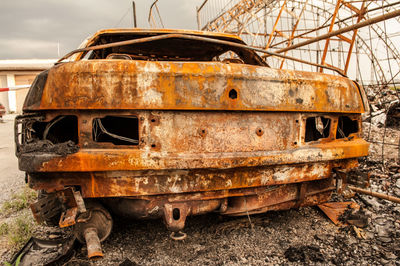 Abandoned rusty wheel on field