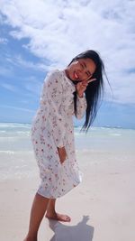 Woman wearing sunglasses on beach against sky