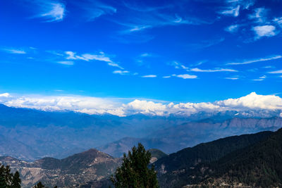 Scenic view of mountains against blue sky