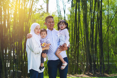 Full length of father and son standing against trees