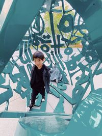 High angle view of boy standing against built structure