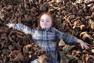 Portrait of cute boy with dry leaves