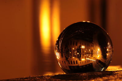 Close-up of illuminated crystal ball on table