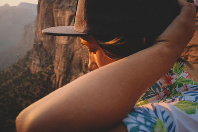 Midsection of woman sitting in hat