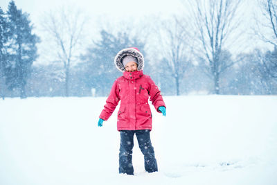 Full length of girl standing on snow covered land