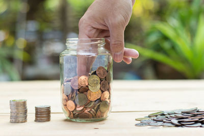 Cropped image of man removing coins from jar