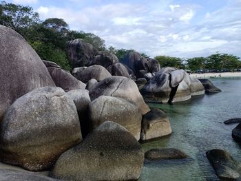 Rocks by sea against sky