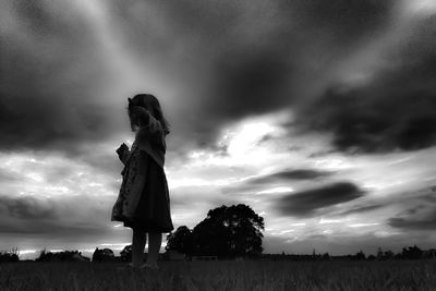 View of field against cloudy sky