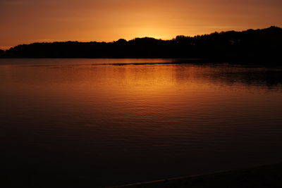 Scenic view of lake against orange sky