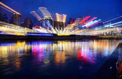 Long exposure of illuminated buildings by river at night