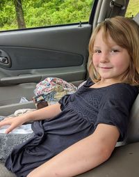 Portrait of young woman sitting in car